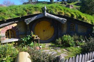 Een hobbithuisje. Een huisje in een heuvel met een gele ronde deur.